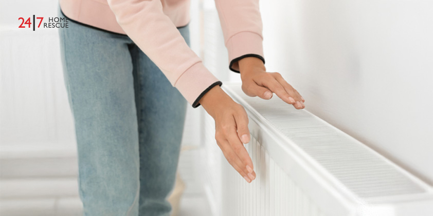 Why Is My Radiator Cold? – Common Faults and How to Fix Them Woman warming her hands on a white heating radiator
