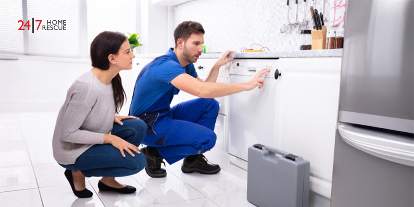 Dishwasher Not Filling with Water? Causes & Fixes Explained A serviceman crouching on the kitchen floor pressing the button of a dishwasher while a woman looks on