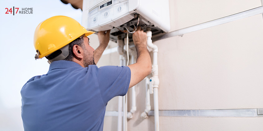 Engineer inspecting an outdoor boiler unit and pipework