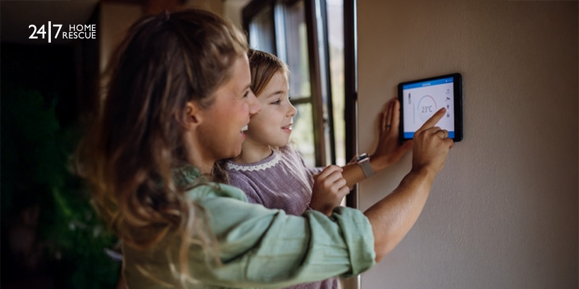 Hive vs Nest Thermostat: Best Smart Choice 2026 Mother and daughter lowering temperature on a smart thermostat for energy efficiency