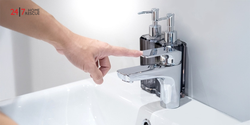Reasons Why There Is no Hot Water in Your Shower A male hand pointing at a chrome water faucet, checking the water tap.