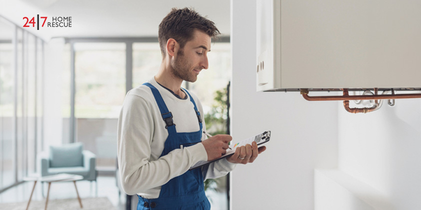 How Often Should a Boiler Be Serviced A boiler engineer using a checklist while inspecting a wall-mounted boiler during a home service visit.
