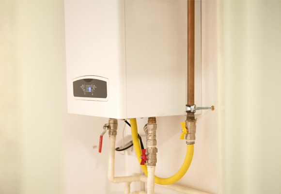 Wall-mounted combi boiler with gas and water pipe connections