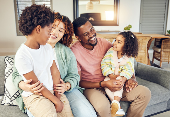 Happy family sitting together on a sofa at home