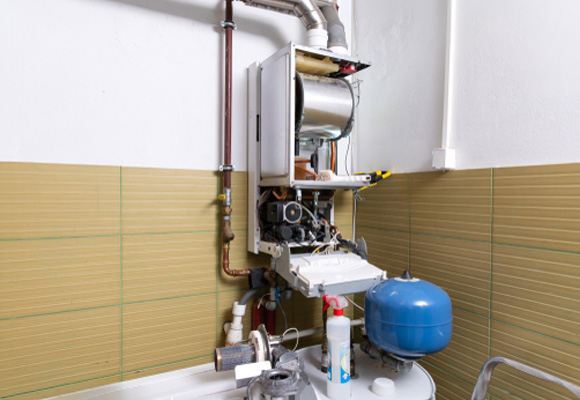 Open boiler casing showing internal components and pressure vessel during a boiler service