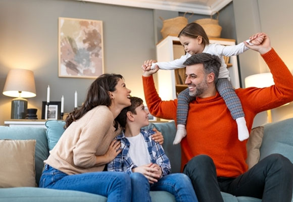 Happy family playing together on a sofa at home