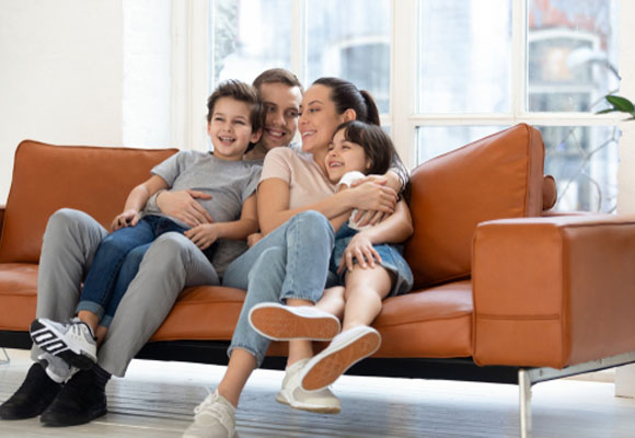 Happy family sitting together on a leather sofa at home