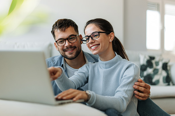 Smiling couple using laptop together